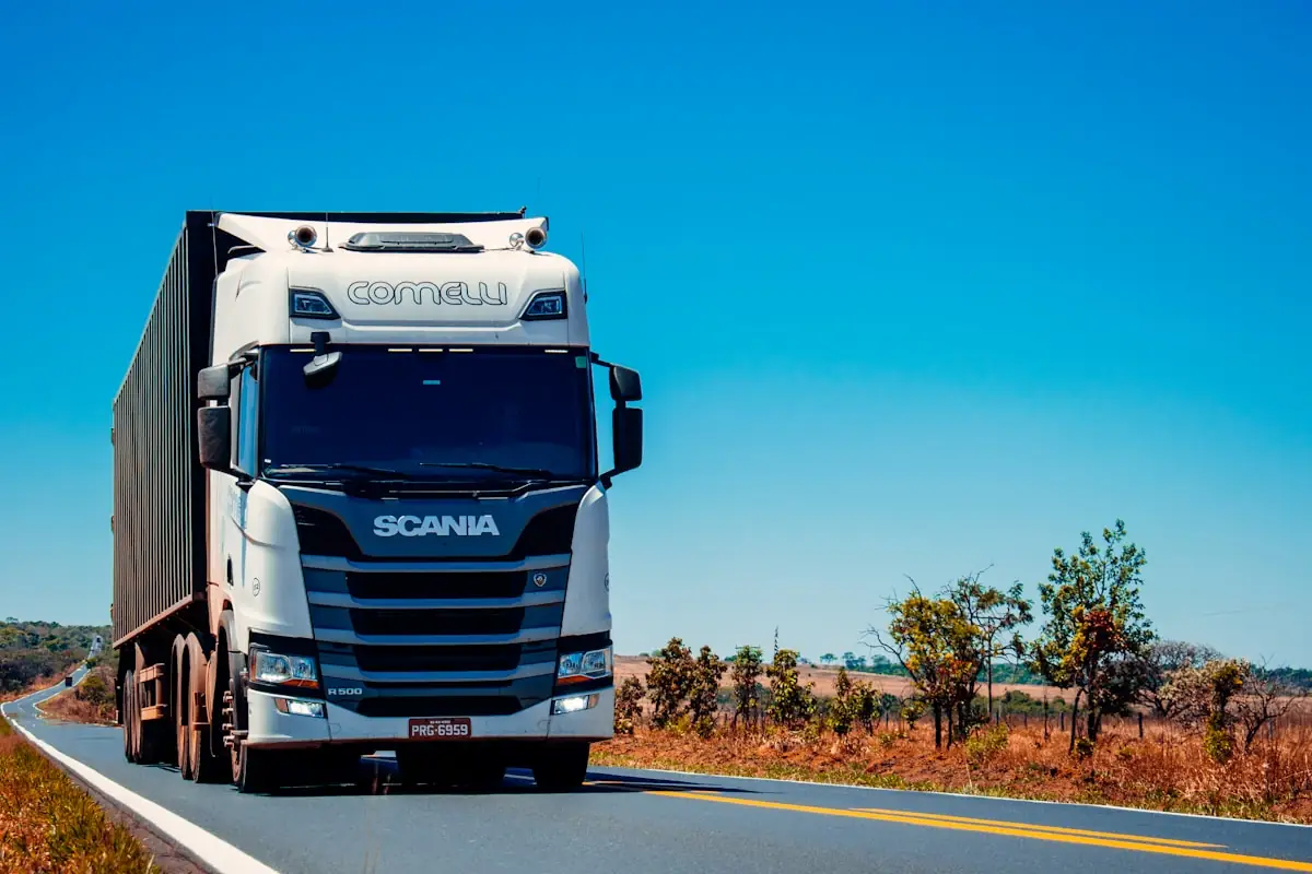 A long-haul truck on an open road under a clear sky